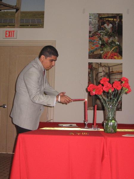 Honorary inductee Dr. Héctor Reyes-Zaga lights a candle in participation of the ceremony.