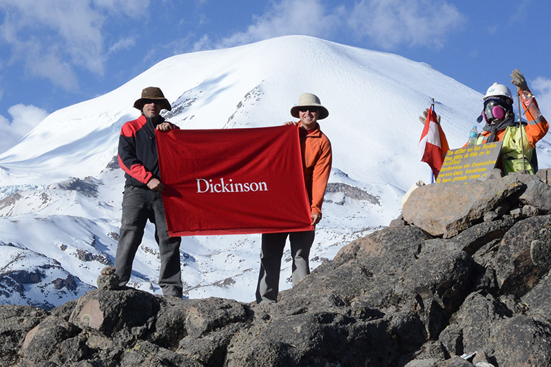 Professor of Earth Sciences Ben Edwards (left) and Will Kochtitzky '16 hold a Dickinson flag in front of a glacierized volcano in Peru, where they conducted fieldwork in 2015. Kochtitzky recently presented original research arising from that work.