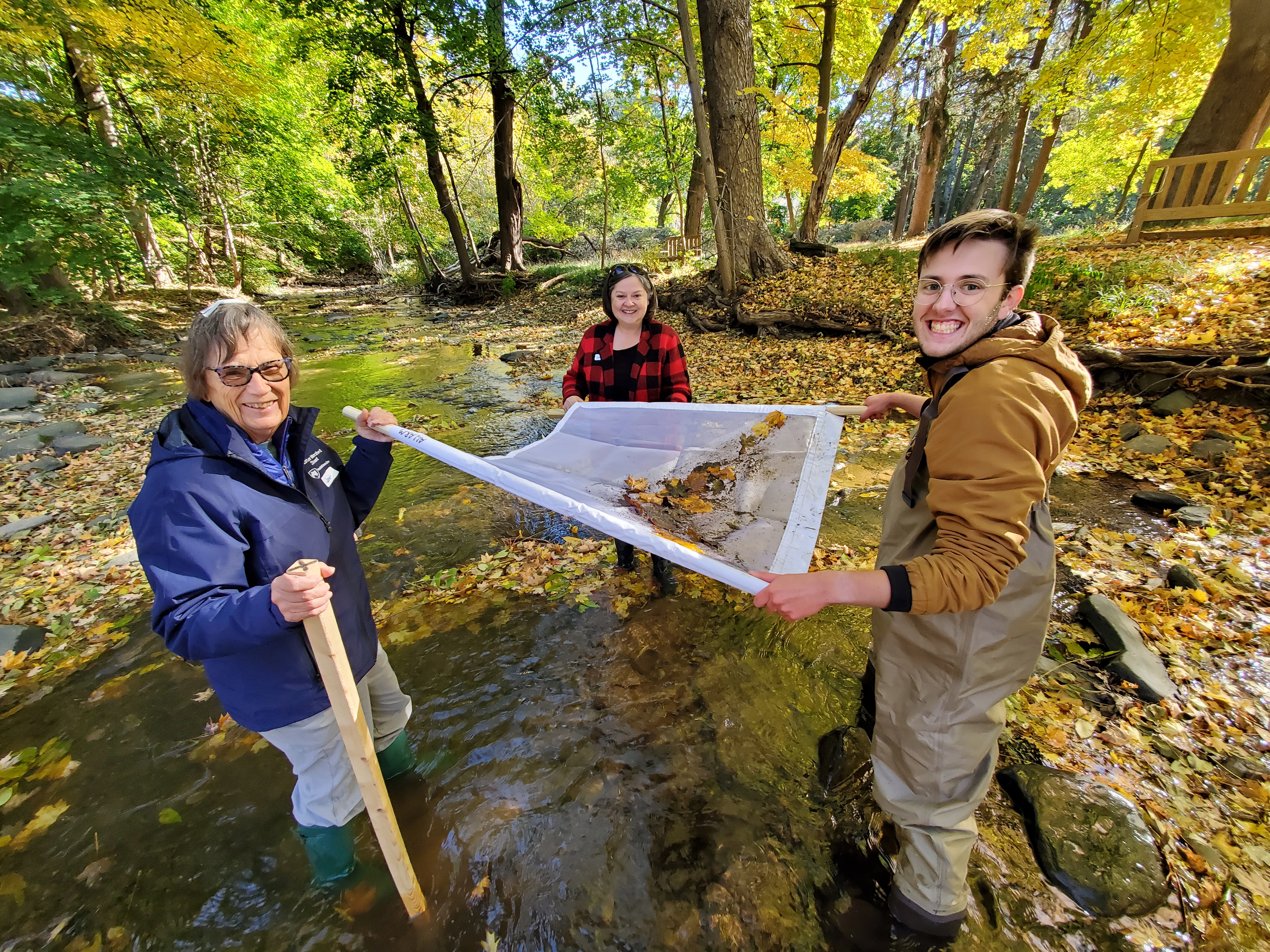 Student Watershed coordinator pose with volunteer monitors in stream