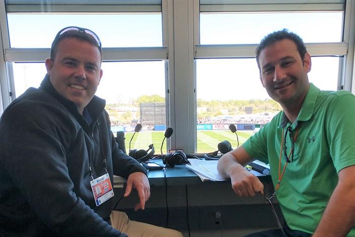 Photo of Geoff Arnold and Brett Hollander inside the Orioles broadcasting booth.