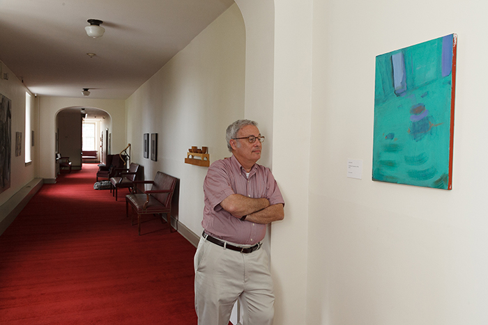 Neil Weissman, provost and dean of the college, poses by a favorite work in the provost&#039;s art collection, displayed in Old West. Photo by Carl Socolow &#039;77.