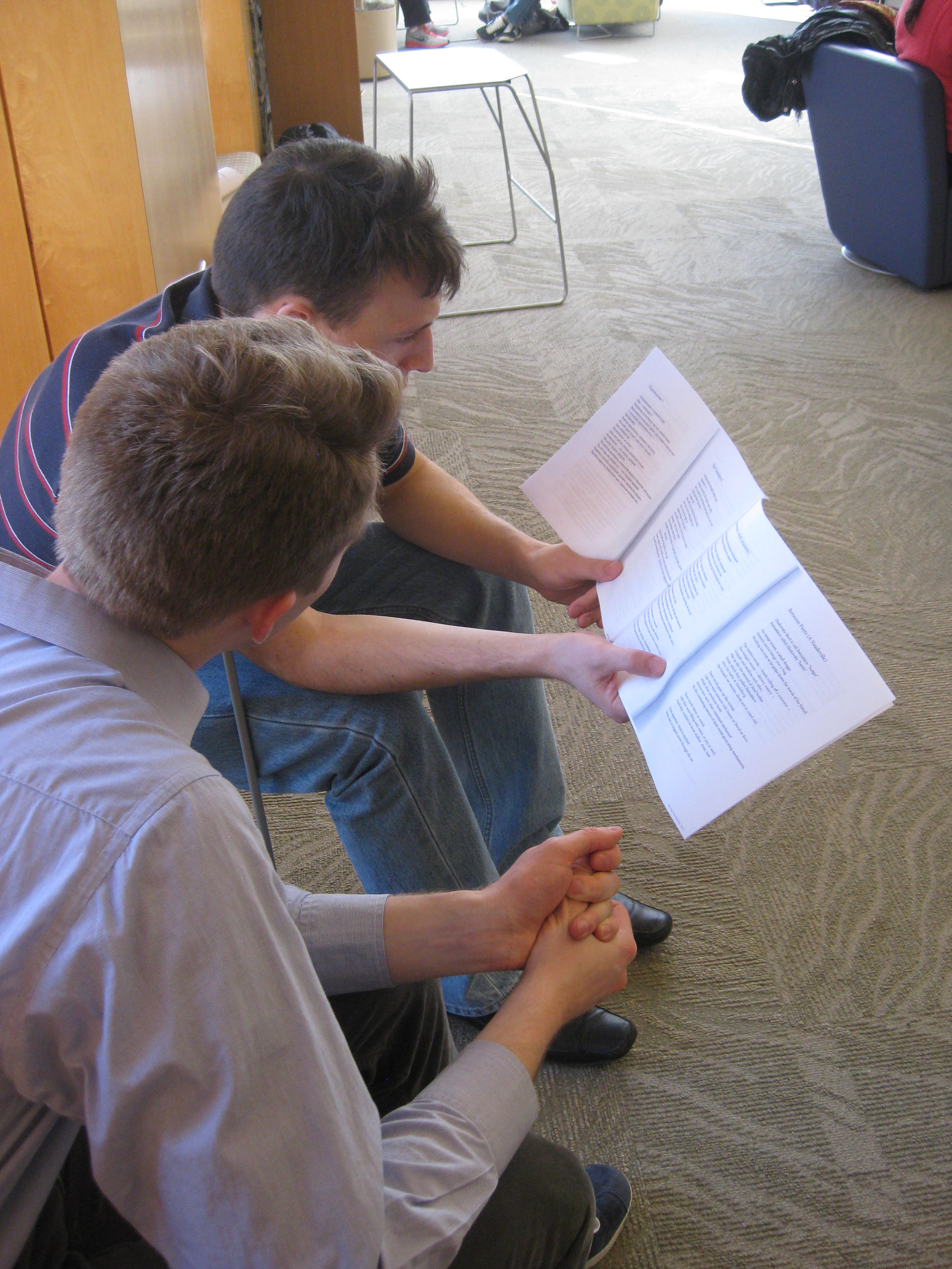 Photo of two students reading along with Barskova's poems.