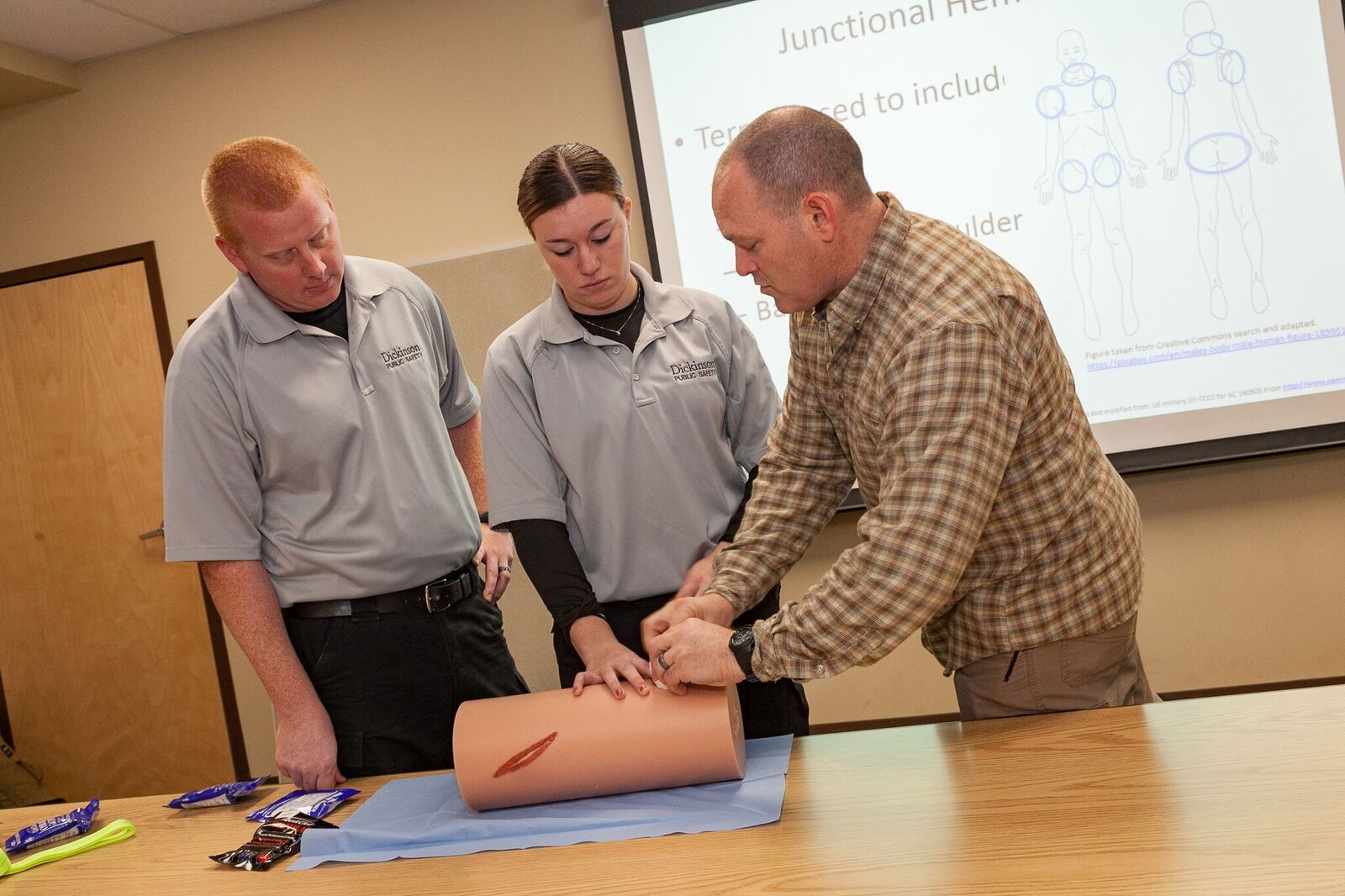 Military Science Instructor John Haiduck (right) instructs two Dickinson Public Safety officers on wound-packing technique during a recent training session for local first responders.