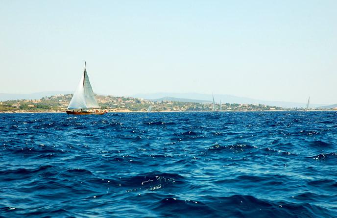 Image of a sailboat in the water off the coast of Greece.