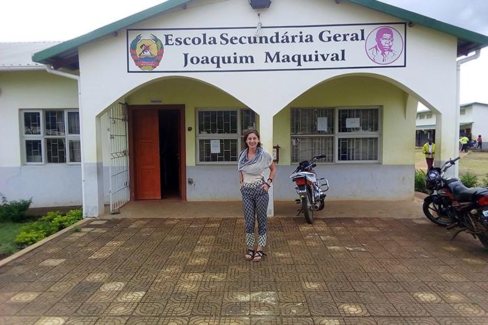Photo of Dickinson alumni Jacqueline Shore in front of a small, white school building in Mozambique.