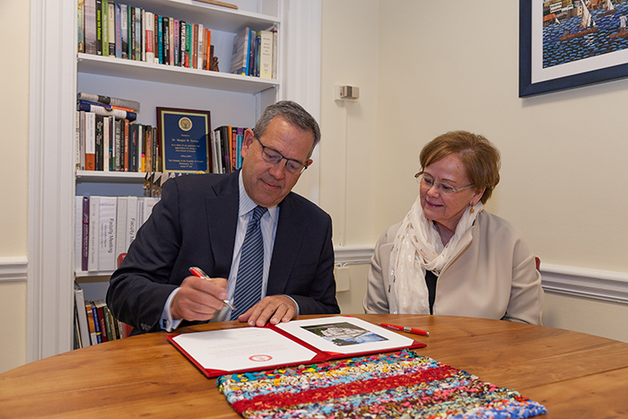 Doug Pauls '80 signs an agreement to support the internship fund, as President Margee Ensign looks on. Photo by Carl Socolow '77.