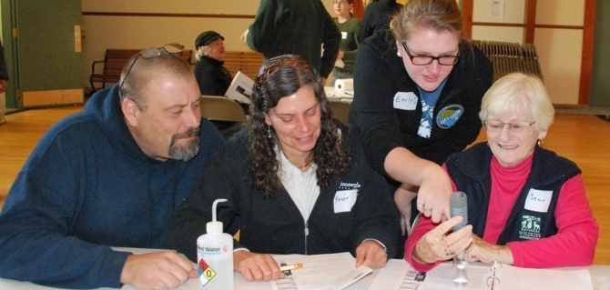 An ALLARM student employee helps volunteers understand the meter.