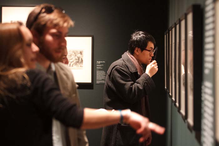 Students examine the finely detailed prints featured in the student-curated exhibition Letters and Lines. Photo by Carl Socolow '77.