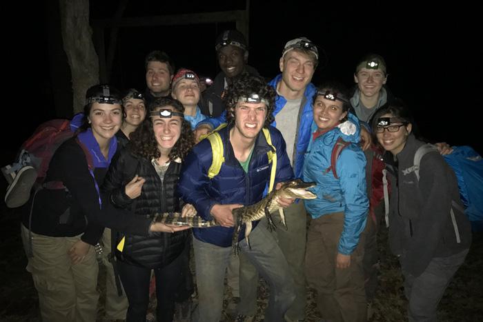 Students with an alligator at night