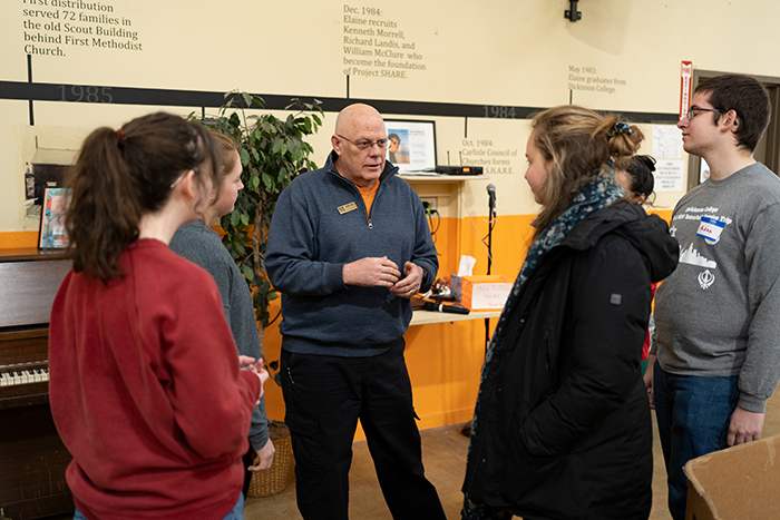 Bob Weed '80 speaks with student volunteers at the Project SHARE food bank. Photo by Joe O'Neill.