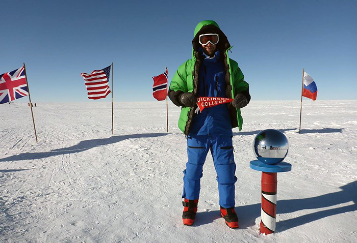 Cameron Kerr '09, a veteran and amputee, displays a Dickinson banner at the South Pole’s Amundsen-Scott Research Station.