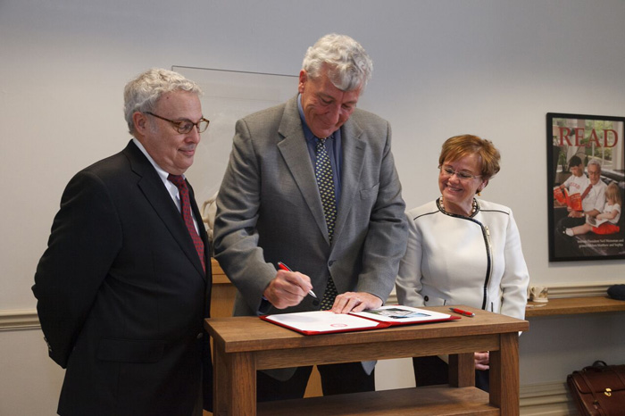 Jim Chambers '78 signs the agreement for his $1 million gift to Dickinson as interim President Neil Weissman and President-elect Margee Ensign look on.