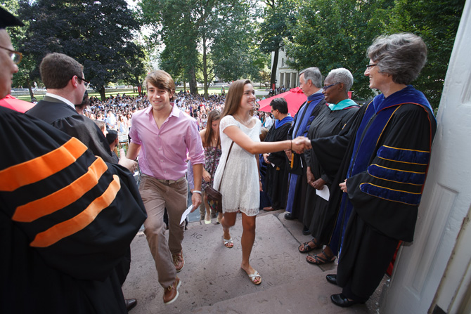 Students walking up the Old West steps and shaking hands with administrators, including Dickinson President Nancy Roseman.