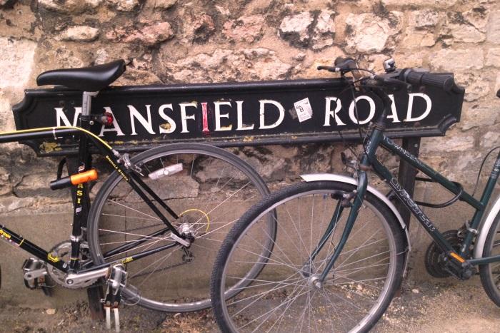 Bicycles rest against a Mansfield Road sign.