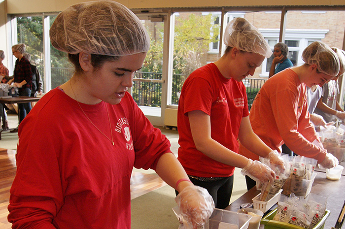 Students package meals for the hungry.
