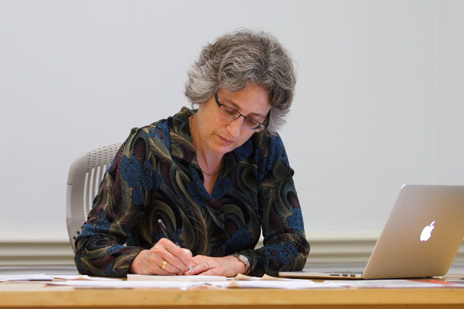 Dickinson President Nancy Roseman writing at her desk.