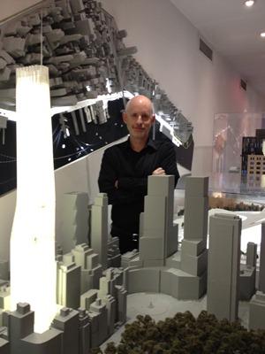 Christopher Sharples standing next to an architectural model.
