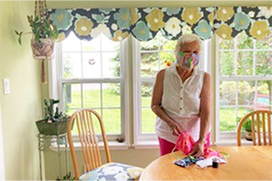Betts Middleton Slim '53 finishes up masks, suitable for medical use. Working in her home, she led a team of 50 volunteers to create 700 for distribution to health care workers, homeless vets and other vulnerable populations