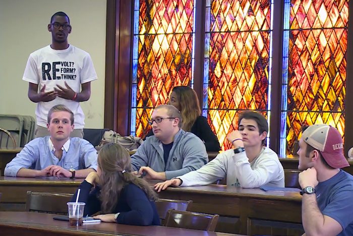 Photograph of a student talking during a Dickinson College Student Senate meeting.