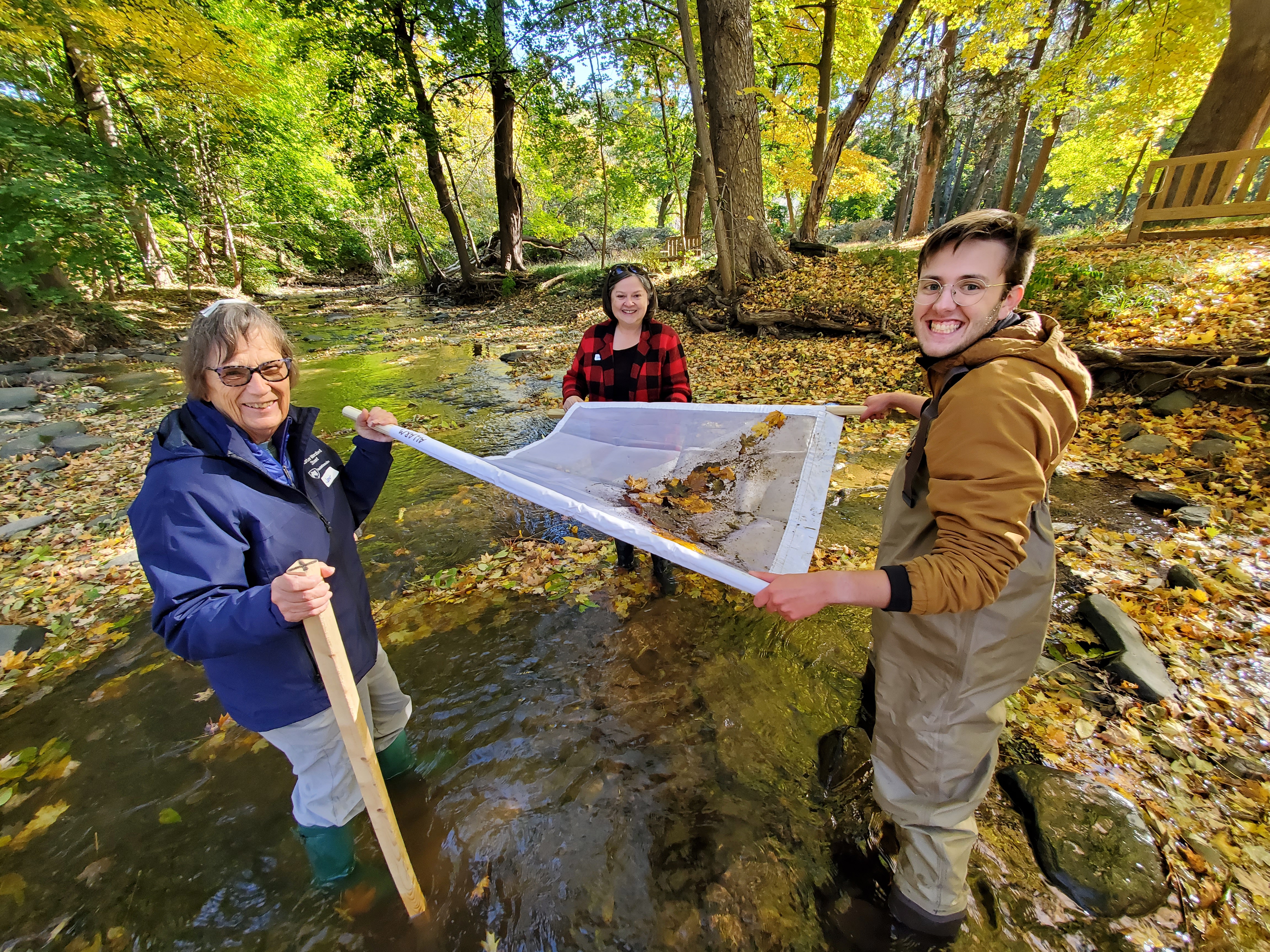 Student Watershed coordinator pose with volunteer monitors in stream 
