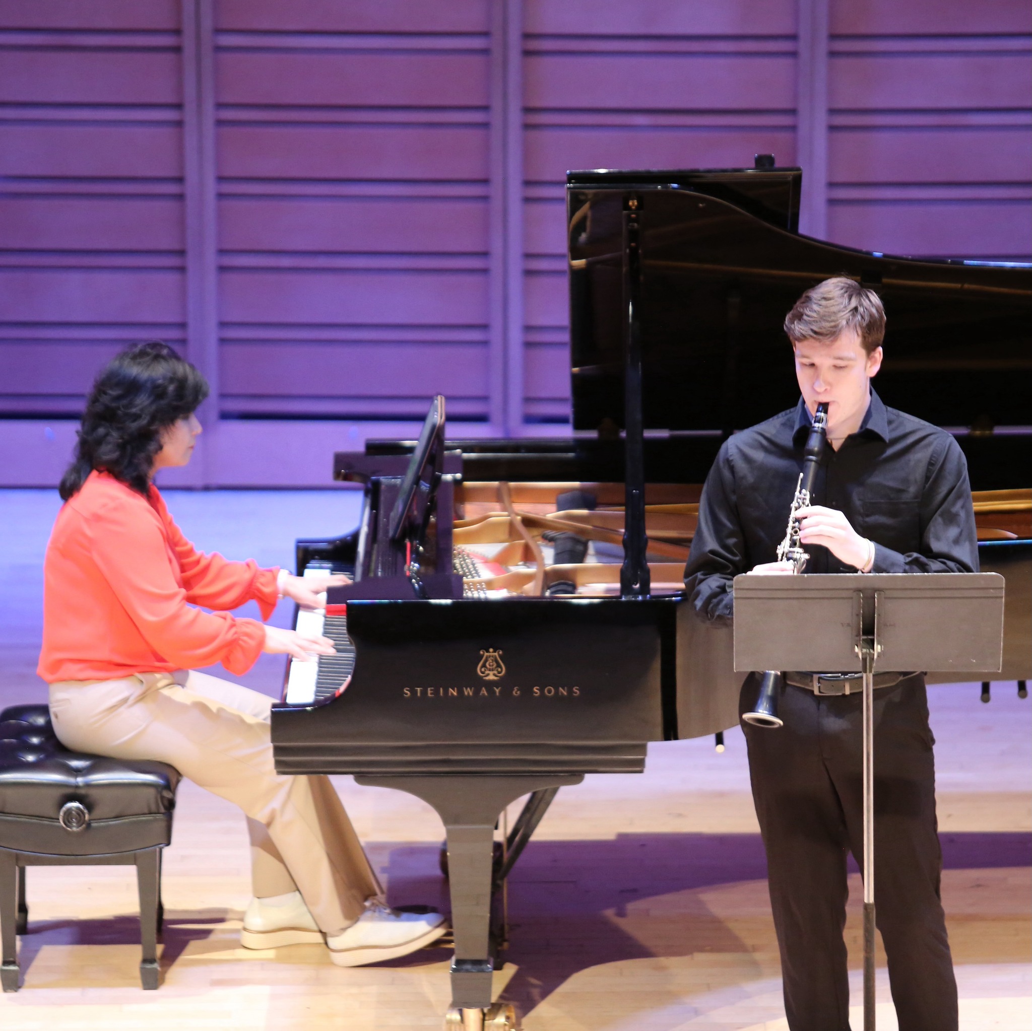 Two young musicians perform onstage.