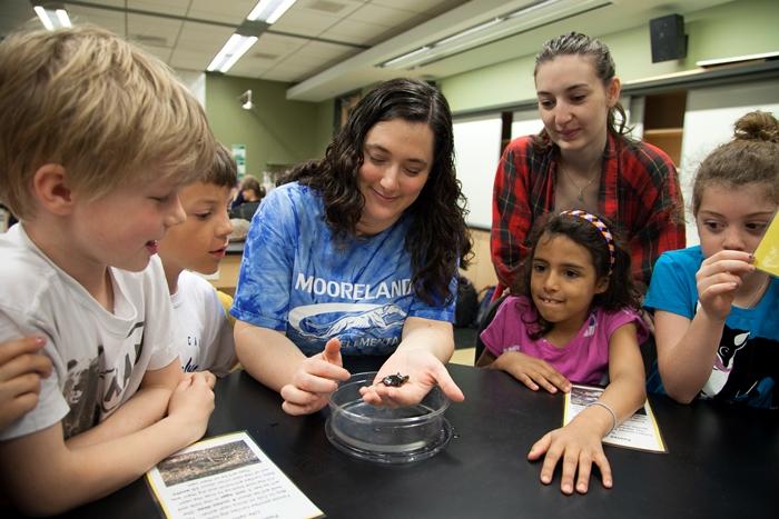 Becca Good holds a frog for her students