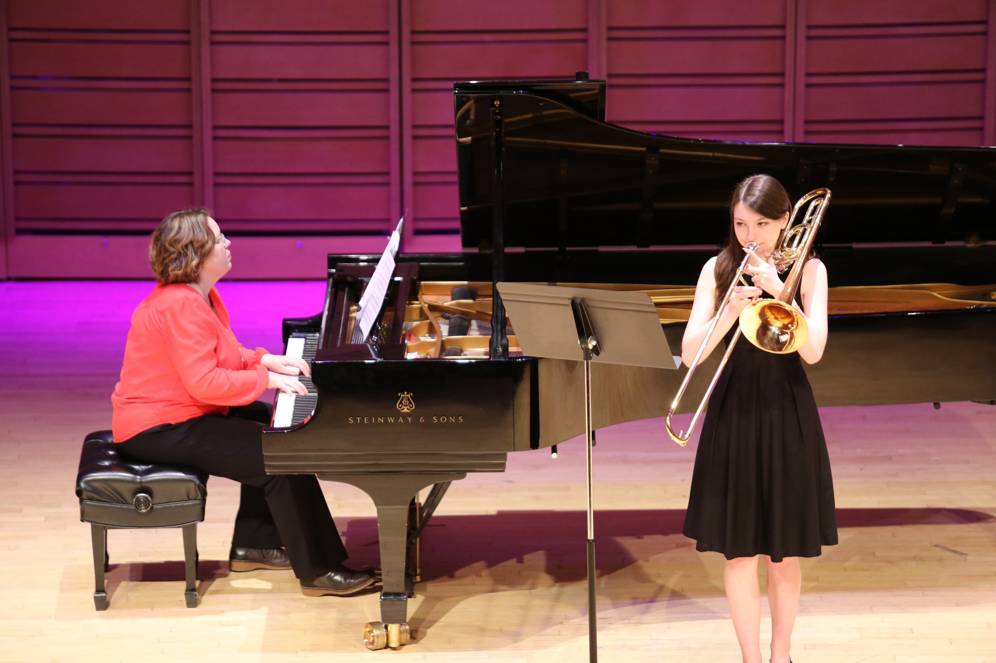 a student musician performs with a faculty pianist onstage.