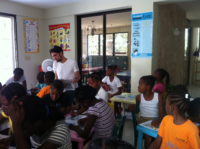 Christopher Brokus &#039;15 works with children on their oral-language skills. Photo by Dominique Pierre, program director of Children of Haiti Project.