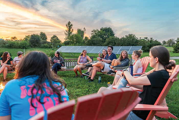 A group of Dickinson students relax in Adirondack chairs at the College Farm