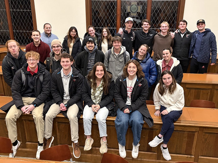 College students pose in an auditorium.