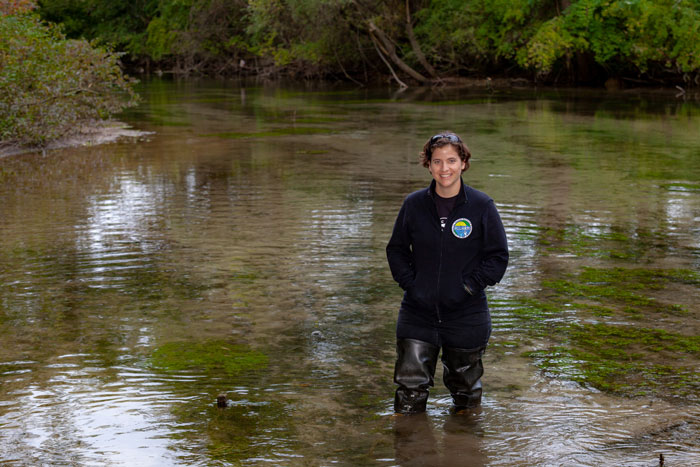 Julie Vastine stands in stream.