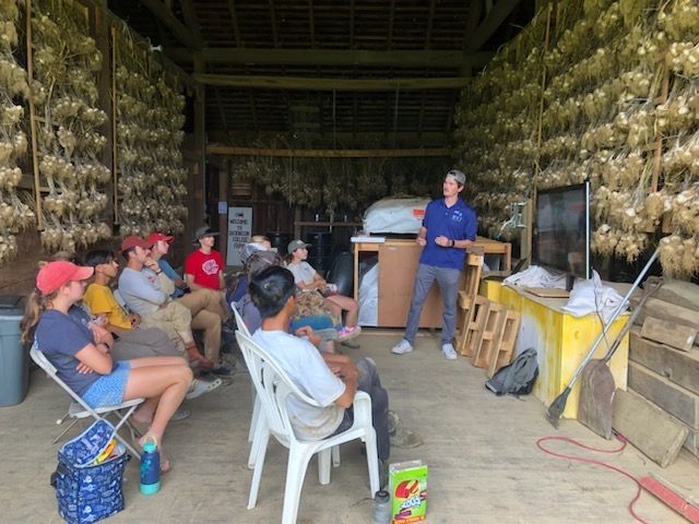 Alex Jones is presenting to a group of people at the Dickinson College Farm