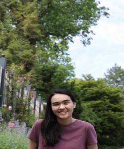 Alicia Murphy is in front of a backdrop of plants