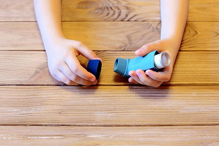 Child's hands with an inhaler.