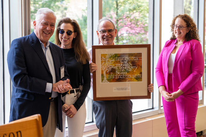 President John E. Jones III ’77, P’11, and Professor of Religion Andrea Lieber present Yale '78 and Audrey Asbell with a handmade paper cut tree designed by local Judaica artist, Susan Leviton, based on a quote from Rebbe Nachman of Breslov, which says in Hebrew, "Tzedakah," followed by the English translation, "Generosity of the heart." The inscription reads, "In gratitude to Audrey and Yale Asbell, for your philanthropic vision which continues to transform Dickinson College and bring many blessings." 