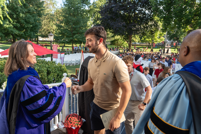 Students ascend the steps of Old West as part of Convocation. Photo by Dan Loh.