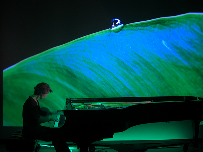 PIanist Jennifer Blyth, professor of music, performs as a video installation by Todd Arsenault, associate professor of art, is projected onstage.