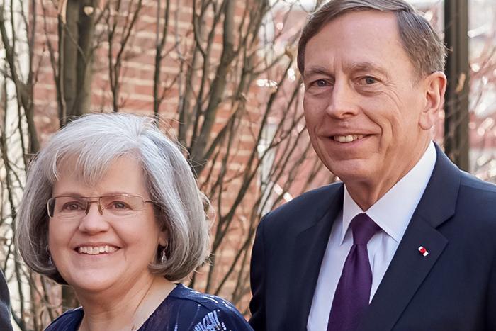 Photo of a woman and man standing outdoors in front of a tree.