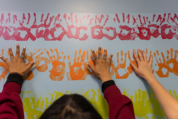 As they refreshed the playroom, the students took care to preserve the handprint rainbow--a favorite part of the original design, created by past Delta Nus. Photo by Dan Loh.