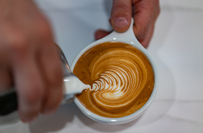 Matt Ramsay, owner of Denim Coffee at The Quarry, pours a perfect cappuccino. Photo by Dan Loh.