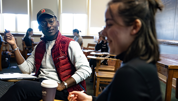 Two students talking in a classroom