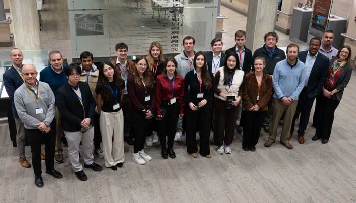 Students, staff, and alums pose for a group photo.