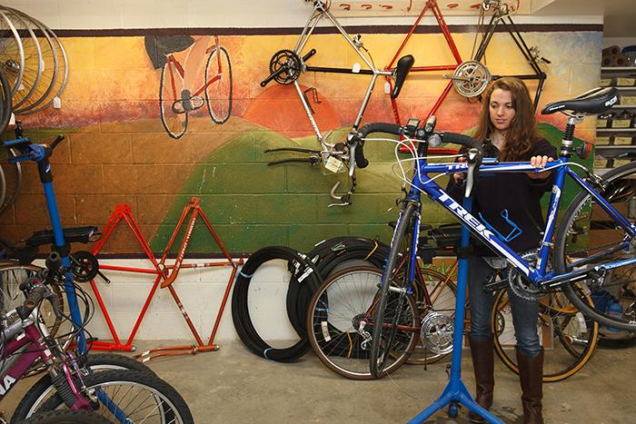 Photo of a woman repairing a bicycle.