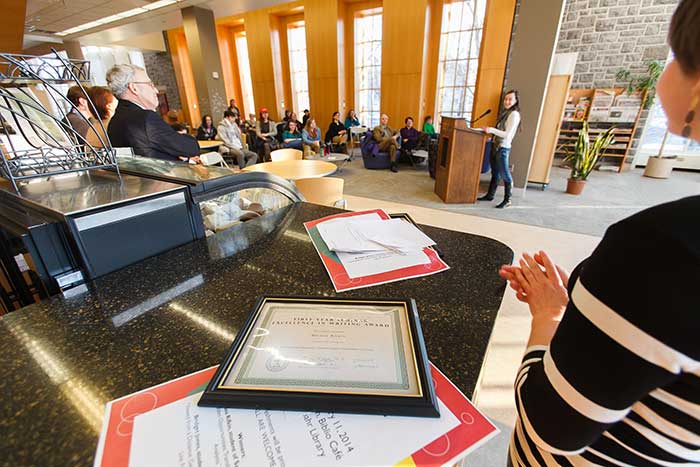 Class of 2017 members Bridget Jones (foreground) and Melissa Rifkin present original research during a reception in their honor.