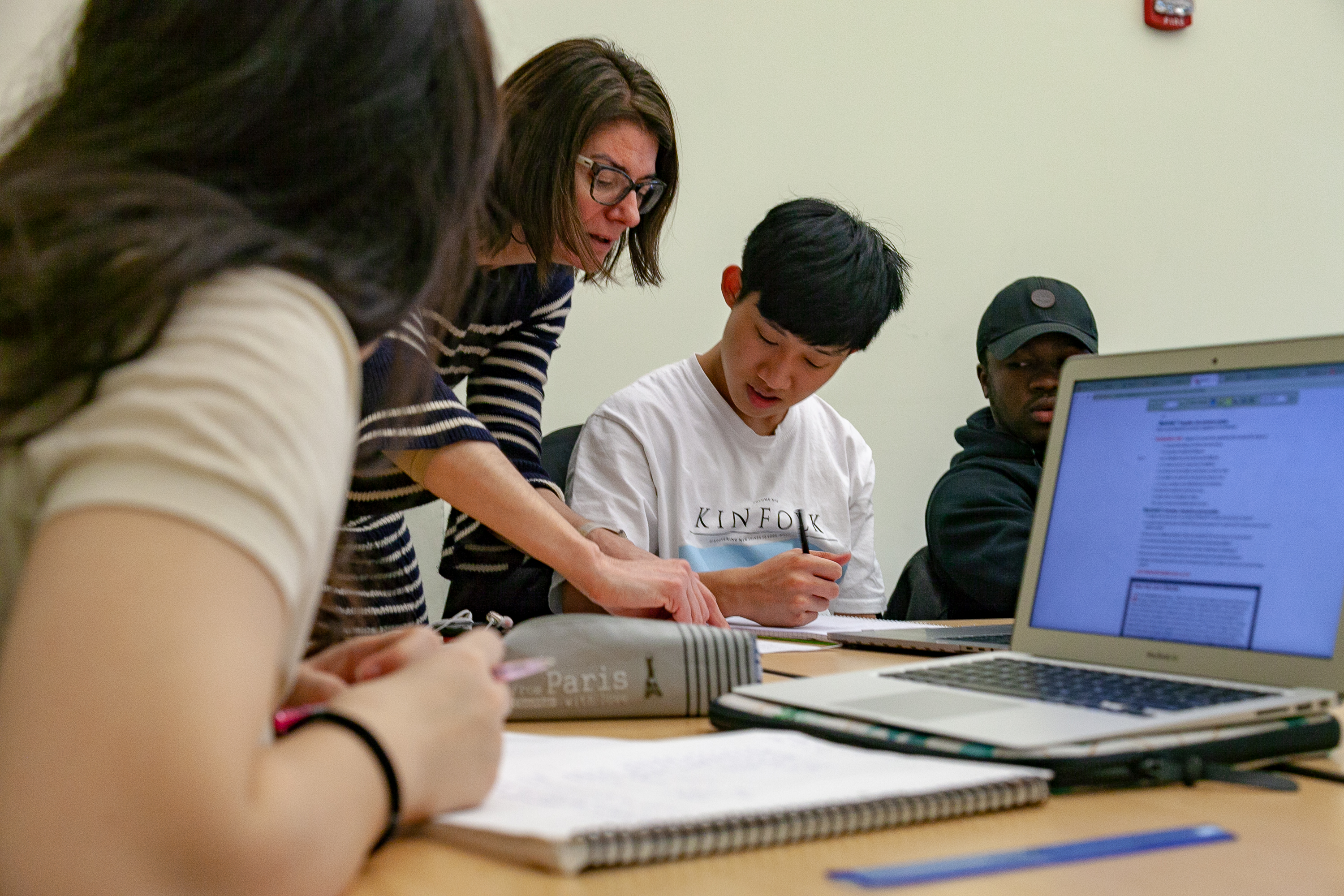 Students and faculty completing research on a computer