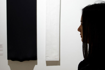 A student studies a work during the 2013 senior studio-art exhibition.