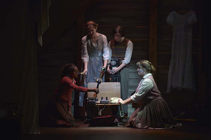 Student-actors performing in the original play "Hidden Stories," lift intriguing objects out of a trunk.