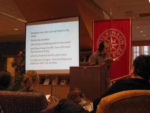 A shot of Kirill Medvedev reading his poetry in the Biblio cafe with an English translation on a powerpoint presentation to the side.