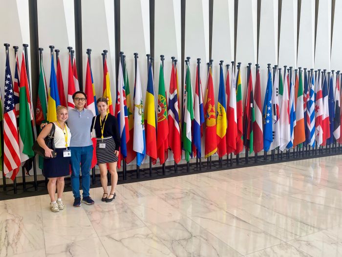 Le poses with Fife and Boss in front of the flags of all 79 EBRD shareholder countries.
