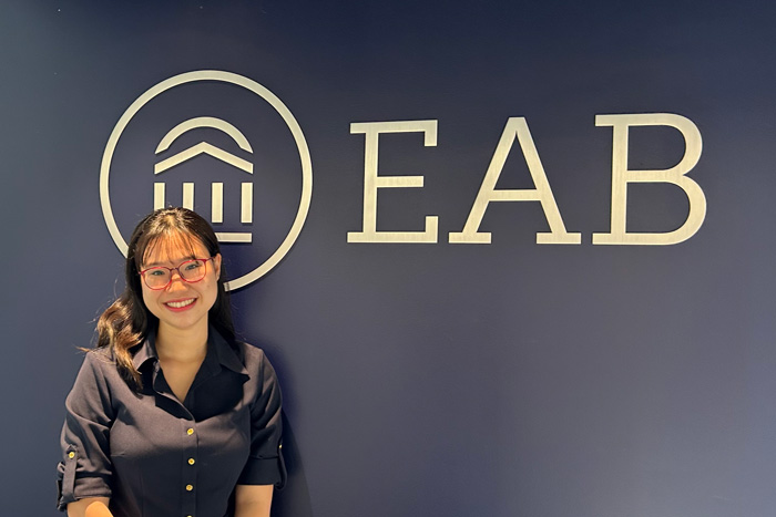 Annie Le in front of the EAB logo